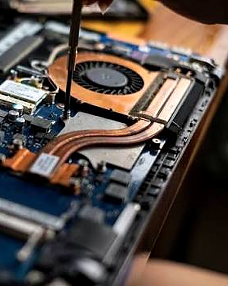 Técnico fazendo manutenção na placa de um notebook